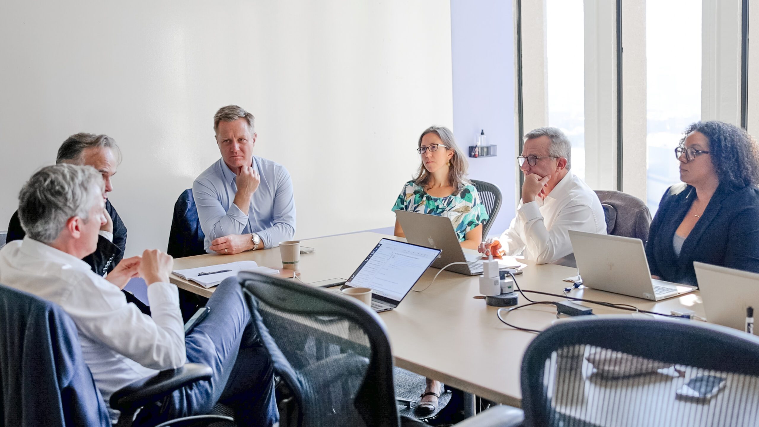 Group of professionals in a meeting room discussing clinical development strategies.