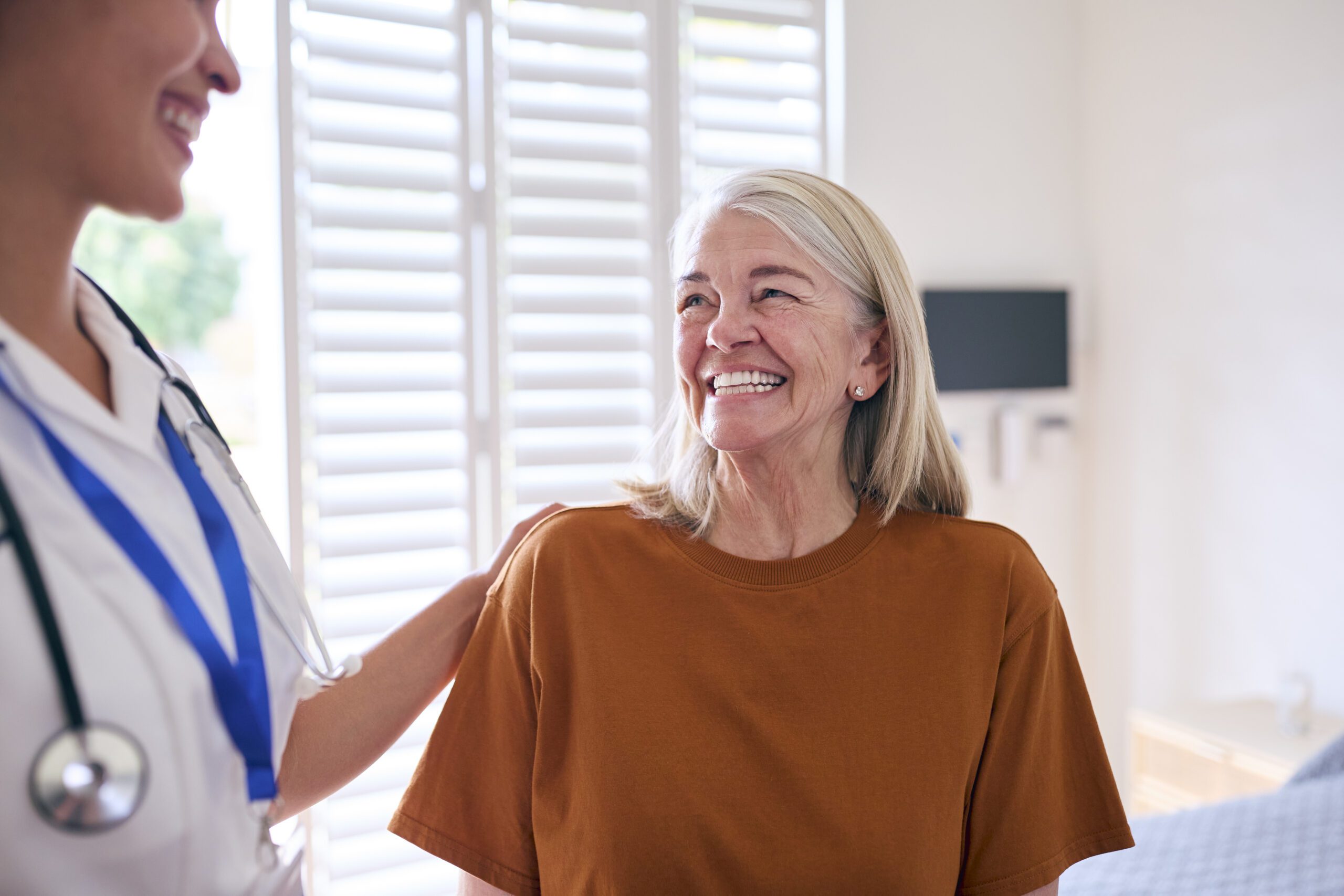 Smiling patient with a healthcare professional, focused on patient access solutions.